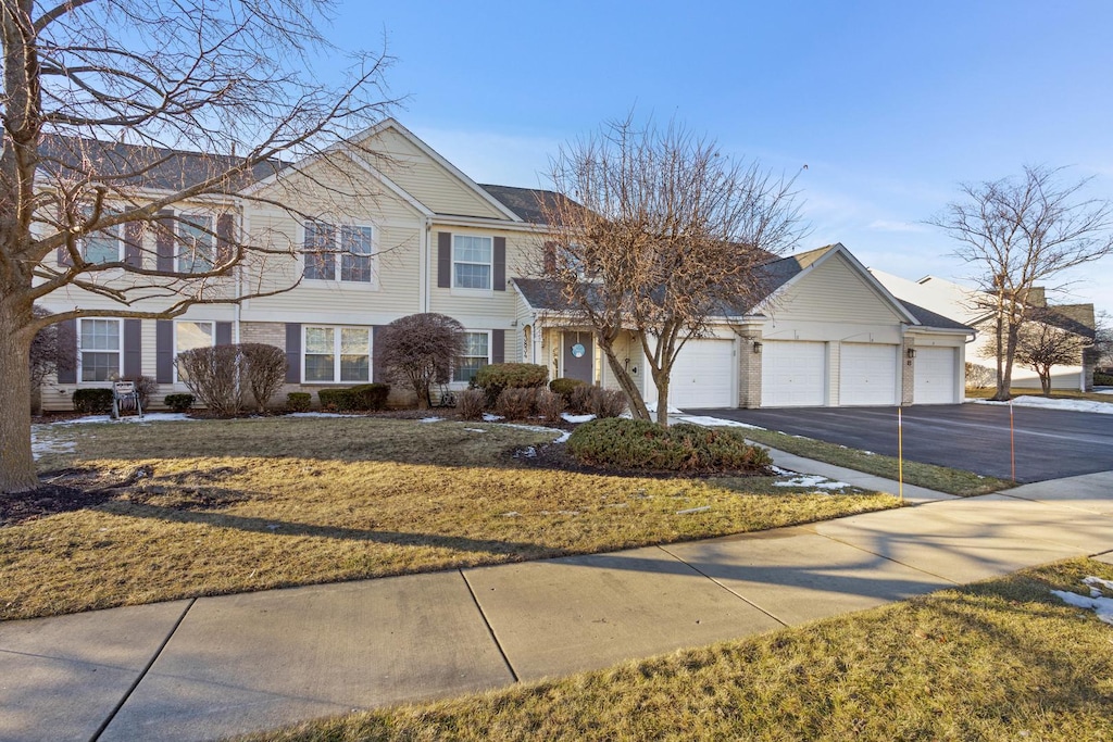 front facade with a garage and a front yard