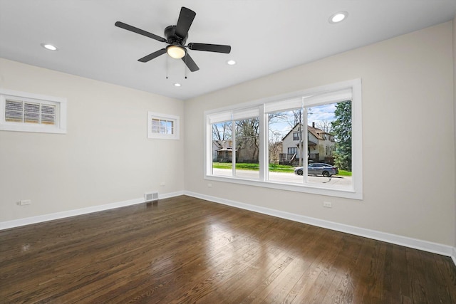 unfurnished room featuring ceiling fan, plenty of natural light, and dark wood-type flooring