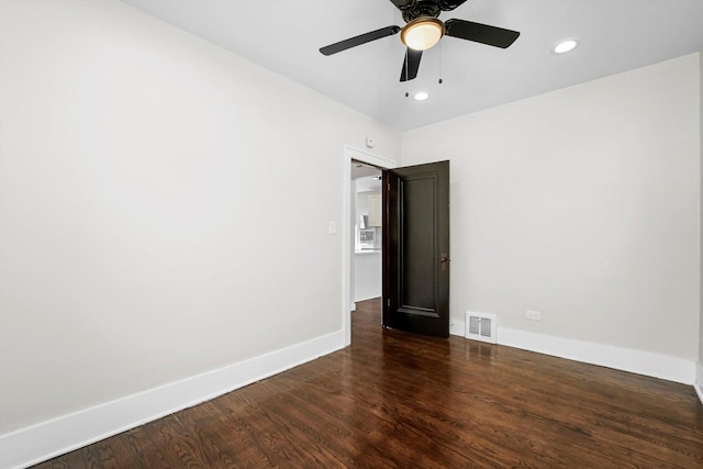 spare room featuring ceiling fan and dark hardwood / wood-style floors