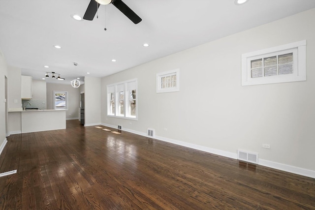 unfurnished living room featuring ceiling fan, dark hardwood / wood-style flooring, and sink