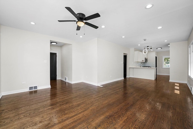 unfurnished living room with ceiling fan and dark hardwood / wood-style floors