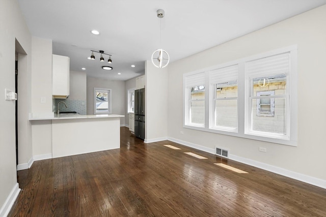 unfurnished living room featuring dark wood-type flooring and sink