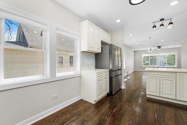 kitchen with stainless steel fridge, ceiling fan, decorative backsplash, dark hardwood / wood-style floors, and white cabinets