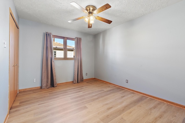 empty room featuring ceiling fan, a textured ceiling, and light wood-type flooring