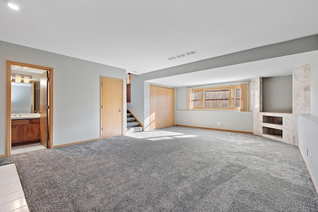 unfurnished living room with light carpet and sink