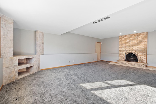 unfurnished living room with a brick fireplace and carpet