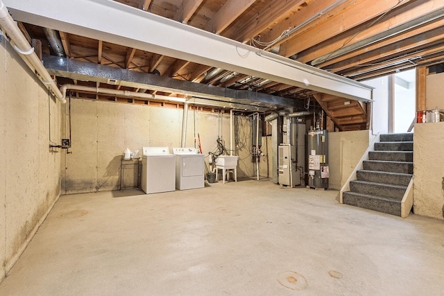 basement featuring sink, heating unit, water heater, and washing machine and clothes dryer