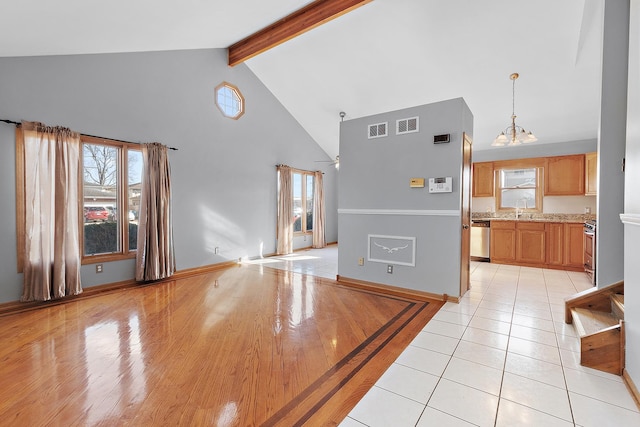 interior space with pendant lighting, beamed ceiling, appliances with stainless steel finishes, high vaulted ceiling, and light tile patterned floors