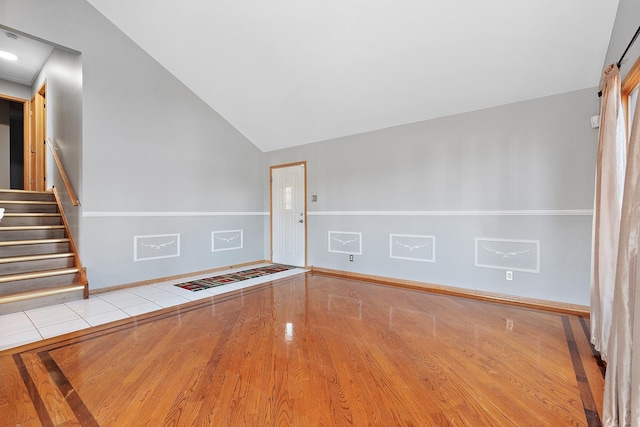 unfurnished room featuring vaulted ceiling and light hardwood / wood-style flooring