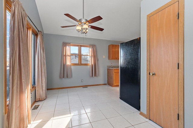 kitchen with ceiling fan, light tile patterned floors, and stainless steel refrigerator