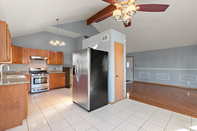 kitchen with beam ceiling, sink, light tile patterned flooring, light stone countertops, and appliances with stainless steel finishes