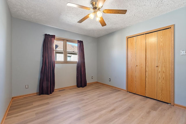 unfurnished bedroom with ceiling fan, a closet, a textured ceiling, and light hardwood / wood-style floors