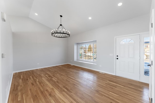 entryway with light wood-type flooring, a chandelier, and lofted ceiling