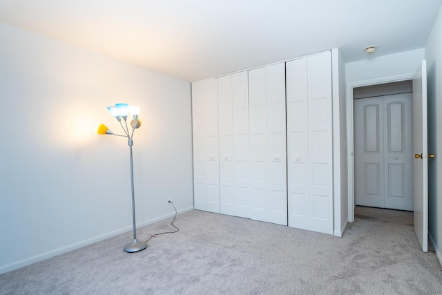 unfurnished bedroom featuring a closet and light carpet