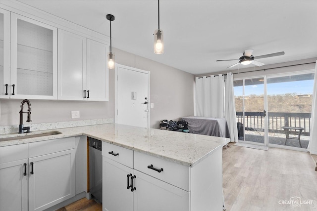 kitchen featuring white cabinetry, stainless steel dishwasher, decorative light fixtures, and sink