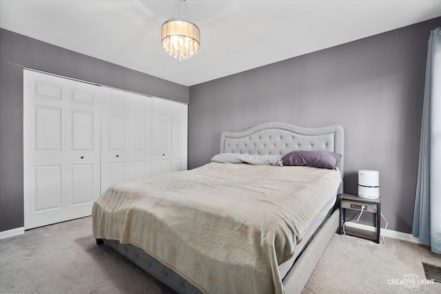 bedroom featuring light colored carpet and an inviting chandelier