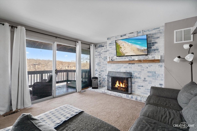 carpeted living room with a brick fireplace