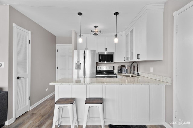 kitchen featuring white cabinets, stainless steel appliances, sink, kitchen peninsula, and light stone counters