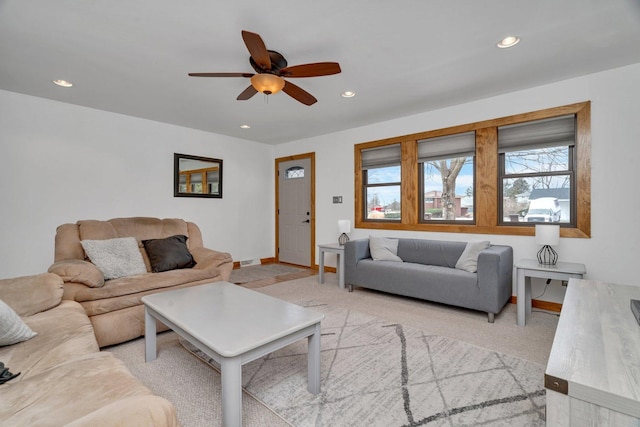 living room featuring ceiling fan, light colored carpet, and a healthy amount of sunlight