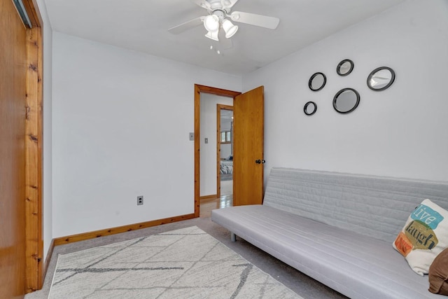 living area featuring ceiling fan and light colored carpet