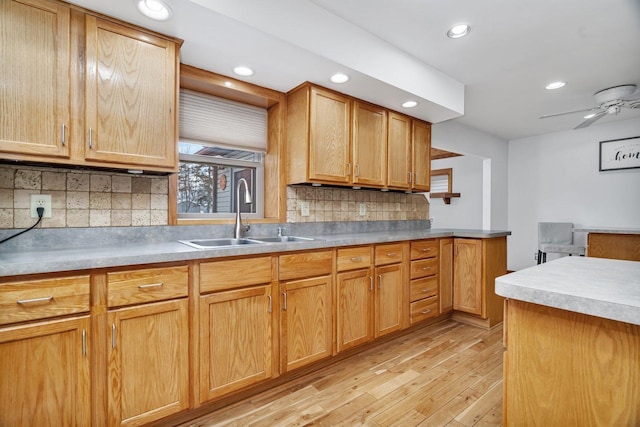 kitchen with decorative backsplash, sink, light hardwood / wood-style flooring, and ceiling fan