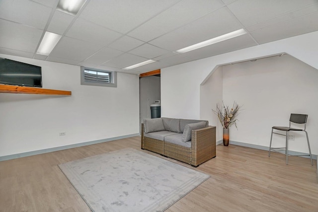 living room featuring light hardwood / wood-style floors and a drop ceiling