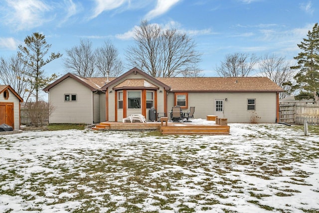 snow covered back of property featuring a deck