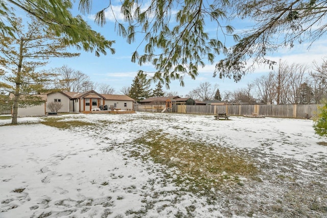 yard covered in snow with a deck