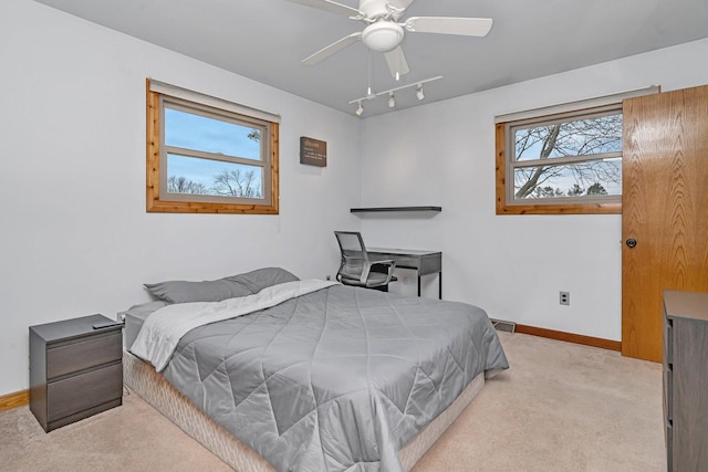 bedroom with ceiling fan, light colored carpet, and rail lighting