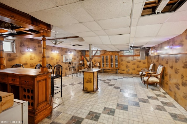 basement with a paneled ceiling and wooden walls