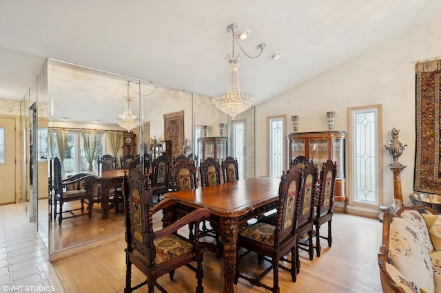 dining space featuring vaulted ceiling, a healthy amount of sunlight, and an inviting chandelier