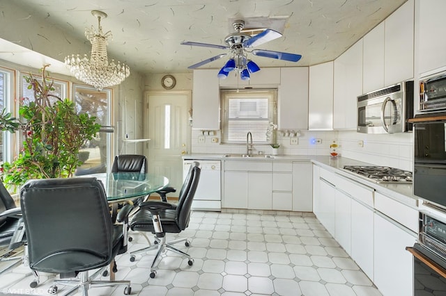 kitchen with white cabinetry, sink, stainless steel appliances, and hanging light fixtures