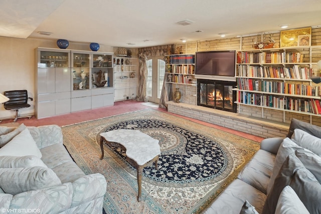 carpeted living room with a brick fireplace