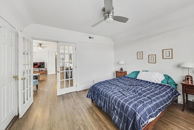 bedroom with ceiling fan, hardwood / wood-style floors, french doors, and vaulted ceiling