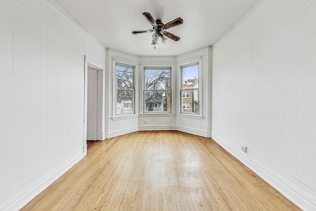 unfurnished room with light wood-type flooring, ceiling fan, and ornamental molding