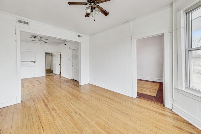 spare room with crown molding, light wood-type flooring, and ceiling fan