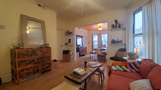 living room featuring ornamental molding and wood-type flooring