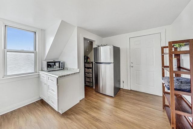 kitchen featuring white cabinetry, light hardwood / wood-style flooring, and stainless steel appliances