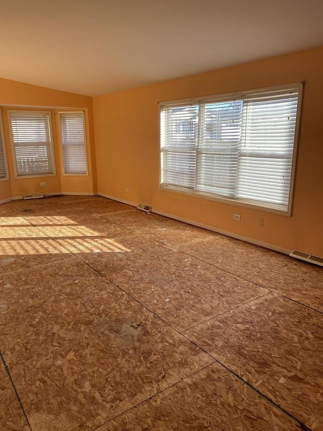 spare room featuring lofted ceiling