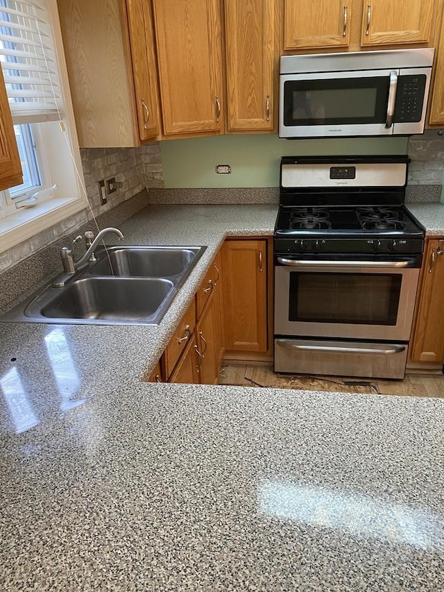 kitchen featuring sink, stainless steel appliances, and tasteful backsplash