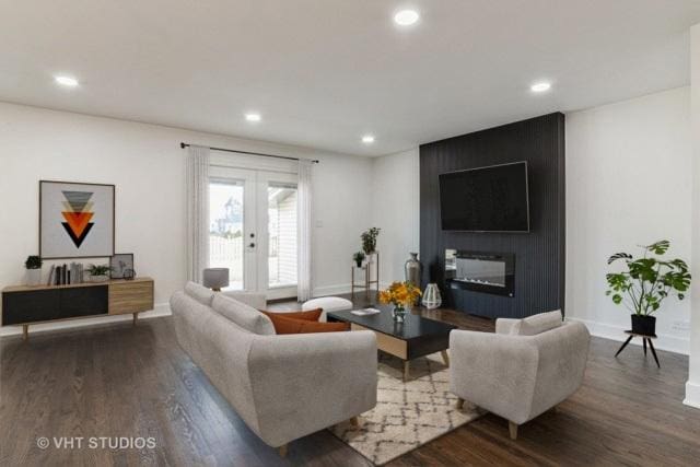 living room featuring french doors, a large fireplace, and dark hardwood / wood-style flooring