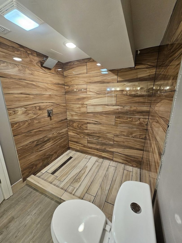 bathroom with toilet, a shower, and hardwood / wood-style floors