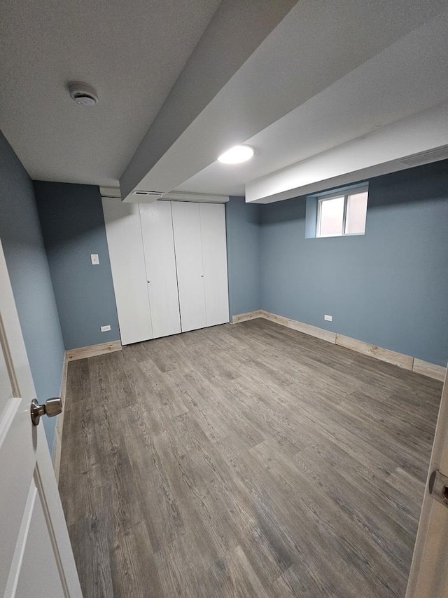 basement with hardwood / wood-style flooring and a textured ceiling