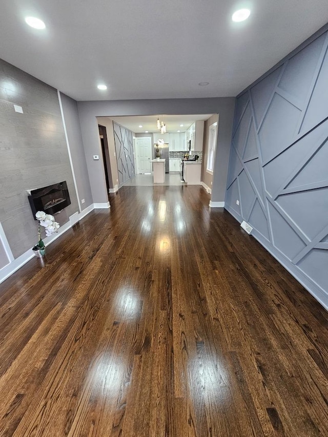 unfurnished living room featuring dark hardwood / wood-style floors and an inviting chandelier