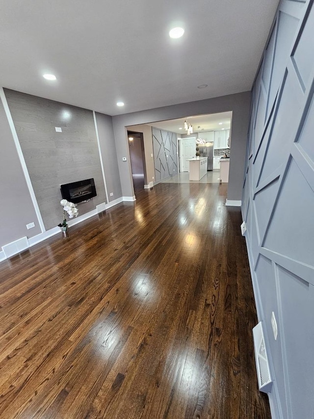 unfurnished living room featuring dark hardwood / wood-style floors and a notable chandelier