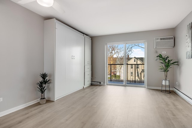 unfurnished room with a baseboard radiator, a wall mounted AC, and light hardwood / wood-style floors