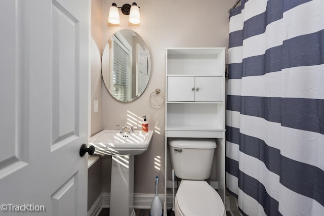 bathroom with toilet and curtained shower