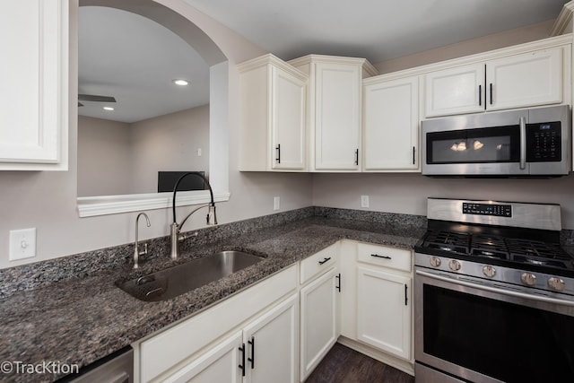 kitchen with sink, white cabinetry, dark stone countertops, and appliances with stainless steel finishes