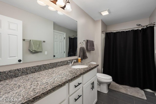 bathroom featuring toilet, tile patterned floors, and vanity