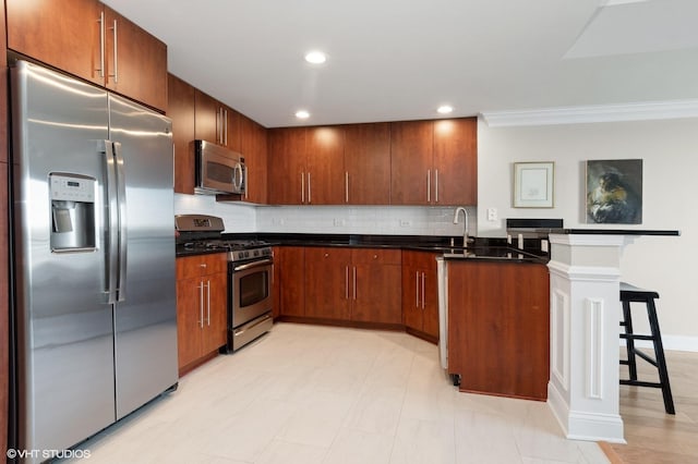 kitchen with sink, crown molding, appliances with stainless steel finishes, tasteful backsplash, and kitchen peninsula